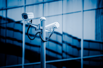 surveillance camera front of modern building,blue toned.