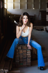 Beautiful asian woman sitting on the wood in warehouse.