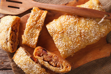 Freshly baked pie stuffed with cabbage and sausages closeup. horizontal top view
