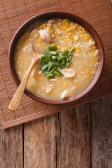 Chinese food: corn soup with chicken and onions close-up. vertical top view
