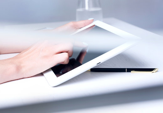 Woman hands using tablet at wooden desk