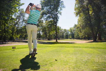 Golf. Golfer teeing off from tee box
