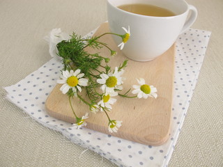 Eine Tasse Kamillentee und Kamillenblüten