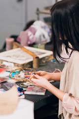 Fototapeta premium Art studio with creating dream catcher artisan. Unrecognizable woman weaving wooden circles for house decoration. Creativity, handicraft, hobby concept