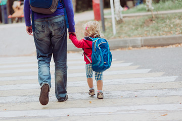 father walking little daughter to school or daycare