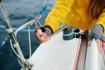 Young strong woman sailing the boat