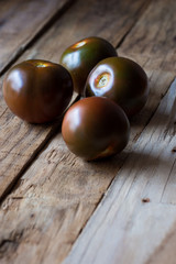 Kumato tomatoes on a rustic wood surface