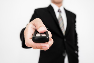 Close-up businessman hand using car wireless remote key, selective soft focus, shallow depth of field 