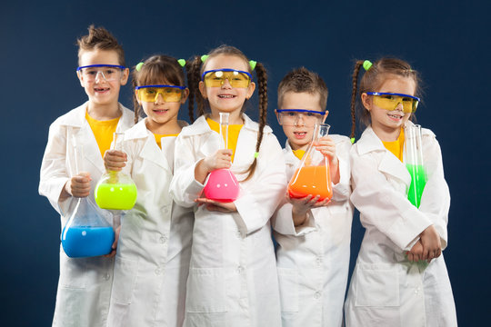 Group happy kids doing science experiments in the laboratory.
