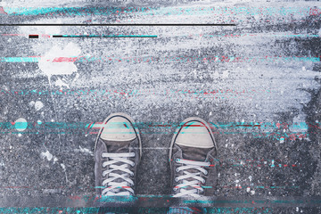 Pair of sneakers on pavement with digital glitch effect