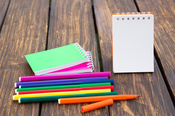 Felt-tip pen and notepad on a wooden background