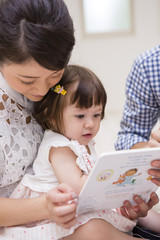 子供に絵本を読む家族