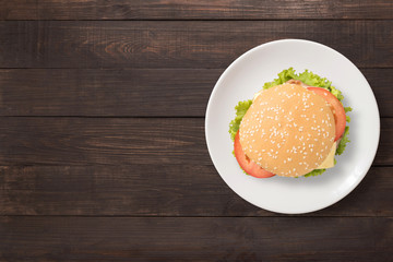Top view BBQ burger on white dish on wooden background. 