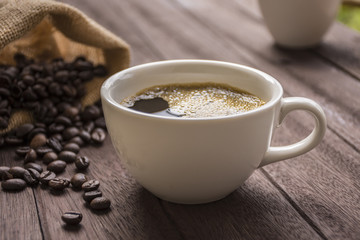 Coffee cup and coffee beans on table