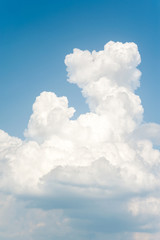 White soft cumulus congestus clouds on blue sky background.