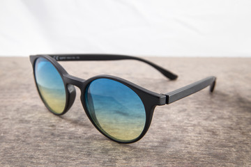 blue and yellow sunglasses on a wooden background close up