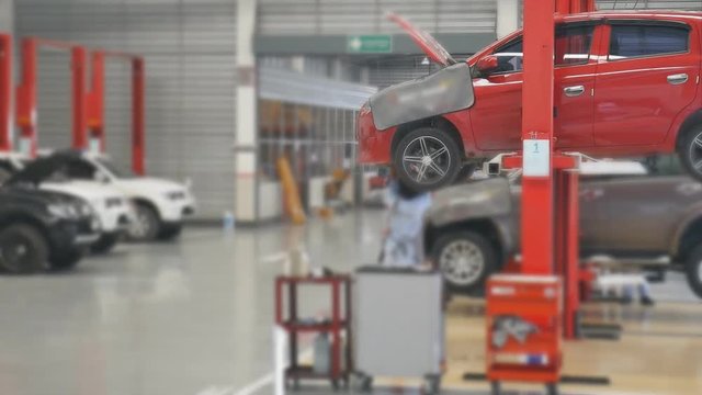 Car service center , Technician service to repair car near car lift in car service room 