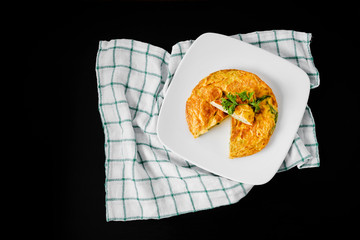 Omelet with vegetables in white ceramic plate