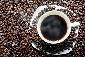 Black coffee cup on beans. Top view, Selective focus, Dark tone.
