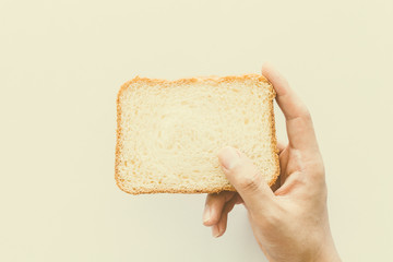 Hands hold a slice of bread on white background