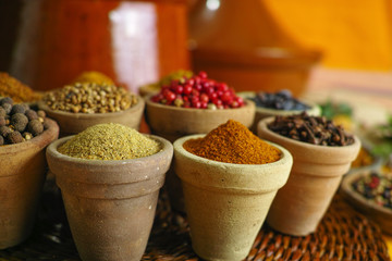 Collection of different spices in old clay bowls in colorful oriental style
