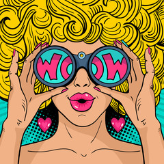 Wow pop art face. Sexy surprised woman with blonde curly hair and open mouth holding binoculars in her hands with inscription wow in reflection. Vector background in pop art retro comic style. - obrazy, fototapety, plakaty