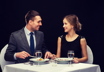smiling couple eating main course at restaurant
