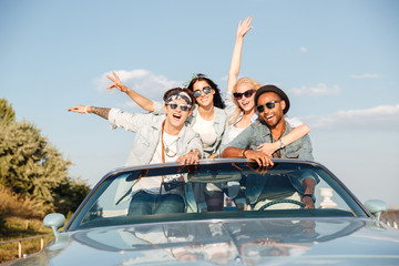 Group of happy young people in cabriolet