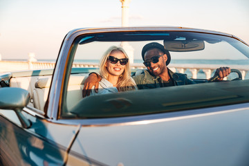 Happy young couple in sunglasses driving cadriolet