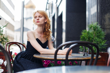 Fototapeta na wymiar young woman in black dress in cafes
