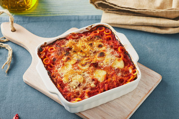 Baked anelletti pasta with mince, sauce and mozzarella. Typical sicilian dish