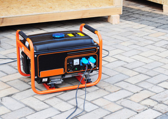 Gasoline Portable Generator on the House Construction Site. Close up on Mobile Backup Generator .Standby Generator - Outdoor Power Equipment - obrazy, fototapety, plakaty