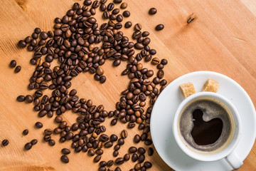 Coffee cup, sugar and coffee beans on wooden background.