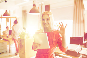 woman with tablet pc showing ok sign at office