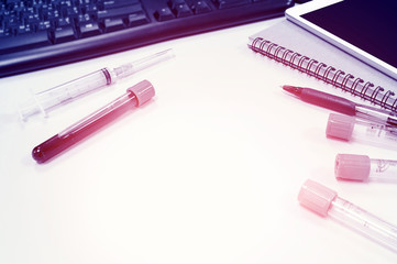 workspace. vacuum tubes for collecting blood samples on white table, over light and blue tone [blur...