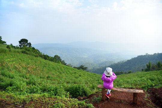 Young Asian girl sitting on a chair with mountain view in Maerim, Mon Jam, Chiangmai, north of Thailand