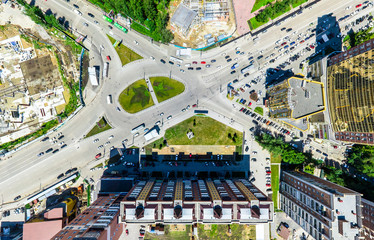 Aerial city view with crossroads and roads, houses, buildings, parks and parking lots, bridges. Urban landscape. Copter shot. Panoramic image.