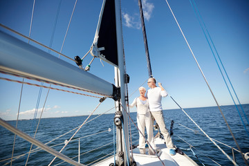 Fototapeta premium senior couple hugging on sail boat or yacht in sea