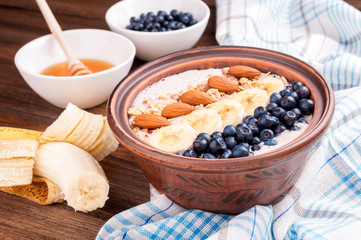 Healthy eating. Breakfast - oatmeal, yogurt, fruits, nuts and berries. Smoothie bowl with banana, blueberries, almond and honey
