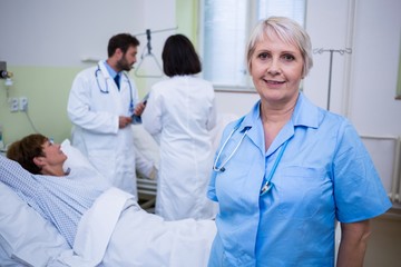 Portrait of nurse standing in hospital room