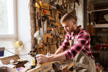 carpenter working with plane and wood at workshop