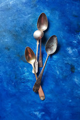 Cutlery, spoons and forks. Bright blue background.
