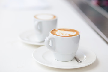 Two cups of cappuccino on counter in cafe