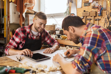 Fototapeta premium workmen with tablet pc and blueprint at workshop