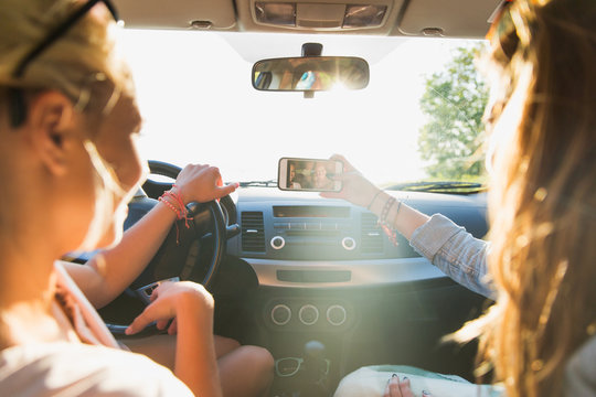 teenage girls or women with smartphone in car