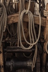 Old wooden sailing ship winch and ropes on the deck of medieval pirate war ship