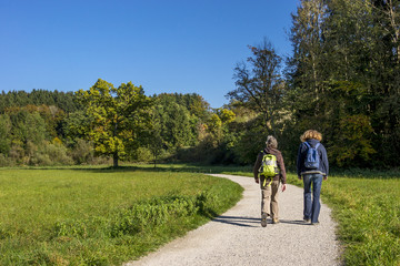 Zwei Frauen wandern &uuml;ber einen Spazierweg in der herbstlichen Landschaft