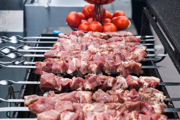 Raw meat skewers on a charcoal grill