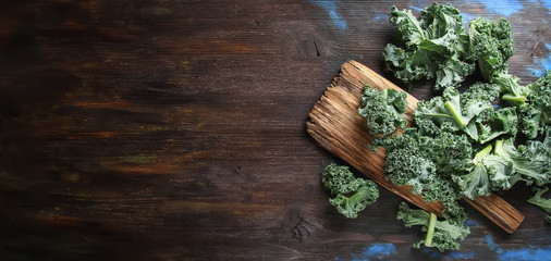 Fresh sliced Italian Kale salad on old wooden board. Dark backgr - obrazy, fototapety, plakaty