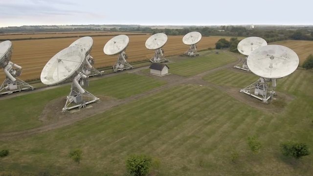 Radio telescope satellite dishes in field, aerial view.